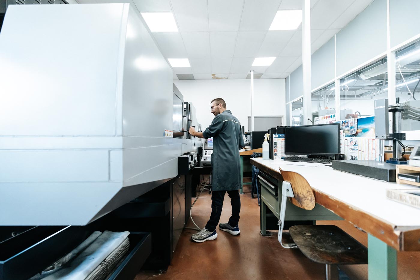 PHOTO D'UN INDUSTRIEL ENTRAIN DE PROGRAMMER UNE MACHINE POUR LA FABRICATION D'UN MOULE INDUSTRIEL POUR INJECTION PLASTIQUE